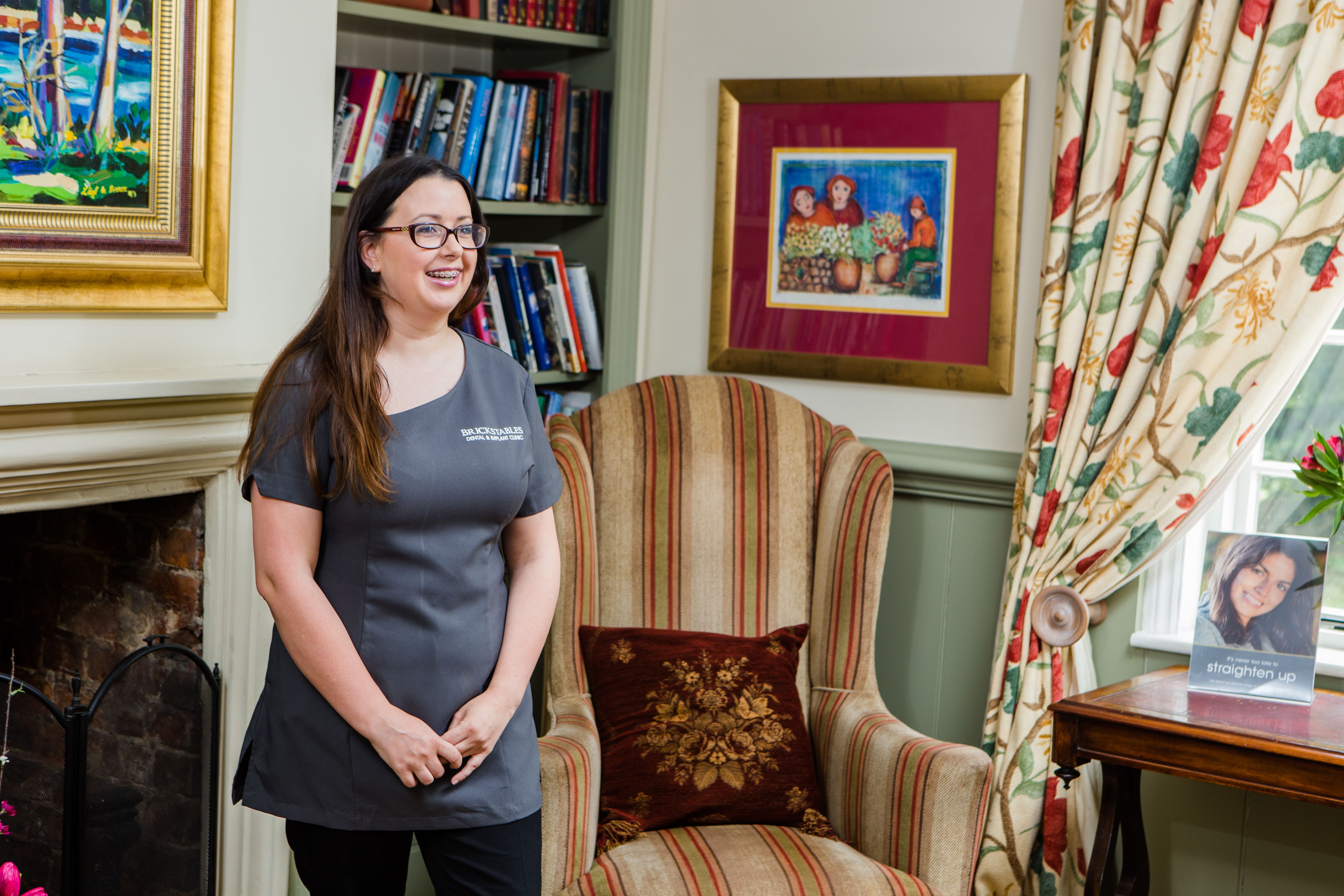 a woman is standing next to a chair in a living room .