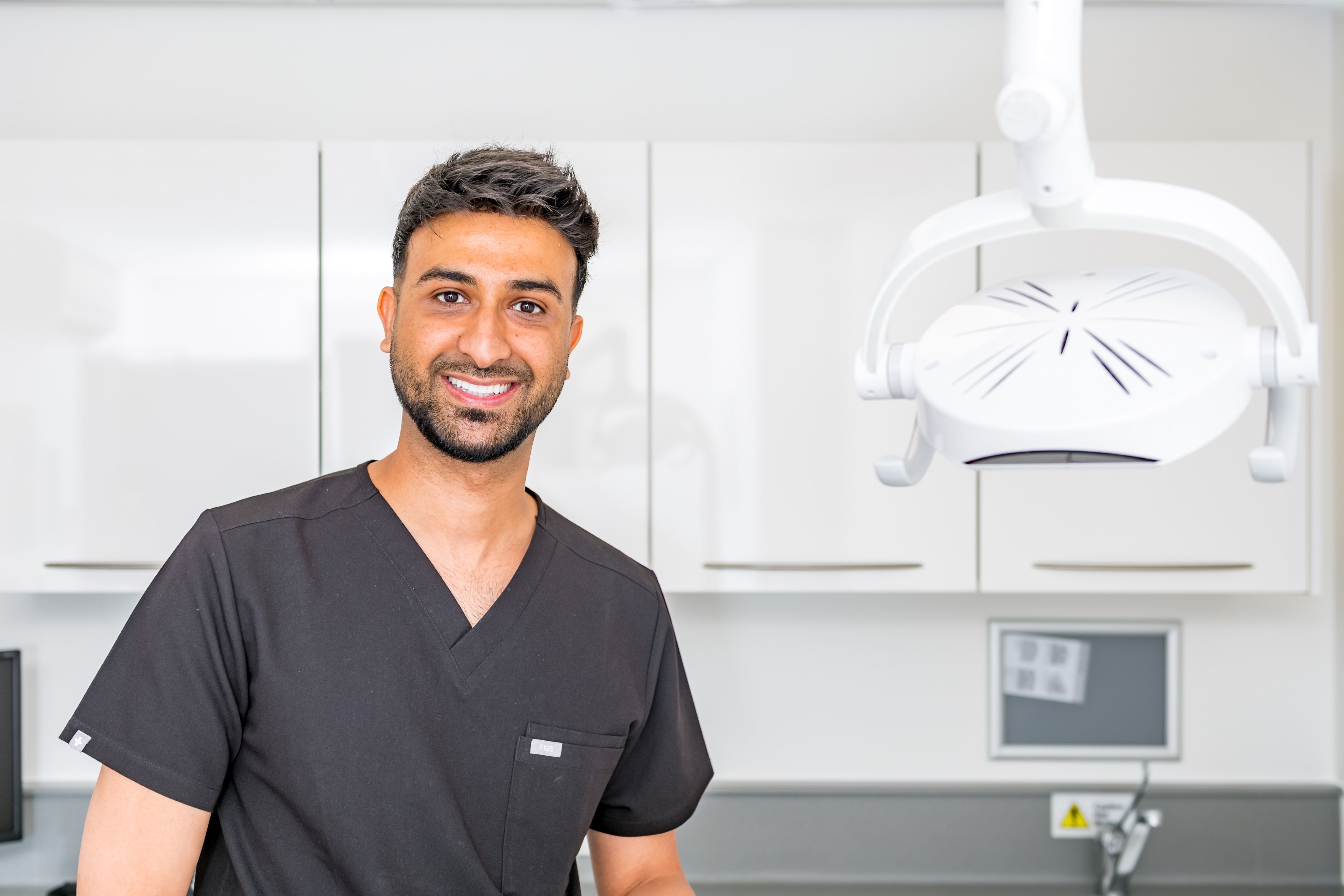 a dentist is standing in front of a dental light in a dental office .